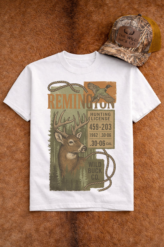 White t-shirt with hunting-themed design featuring a deer and Remington branding, displayed on a brown textured background.